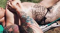 Tattooed horny brunette with big boobs sunbathing in the yard and rubbing sunscreen on her tits Thumb