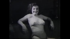 A mature lady with dark silky hair takes part in the filming of a 60s porn film Thumb